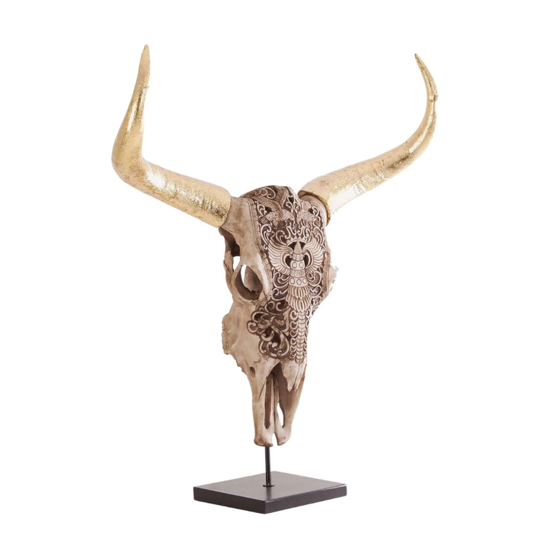 Decorative bull head sculpture on iron base with golden details and engraved motifs.

