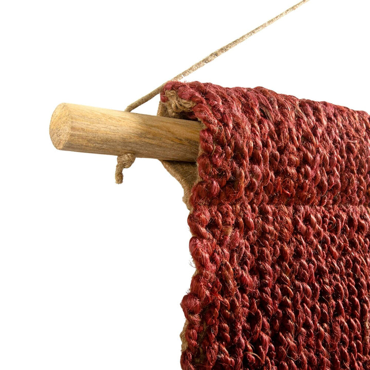 Close-up of handcrafted red jute and cotton wall hanging for boho decor.
