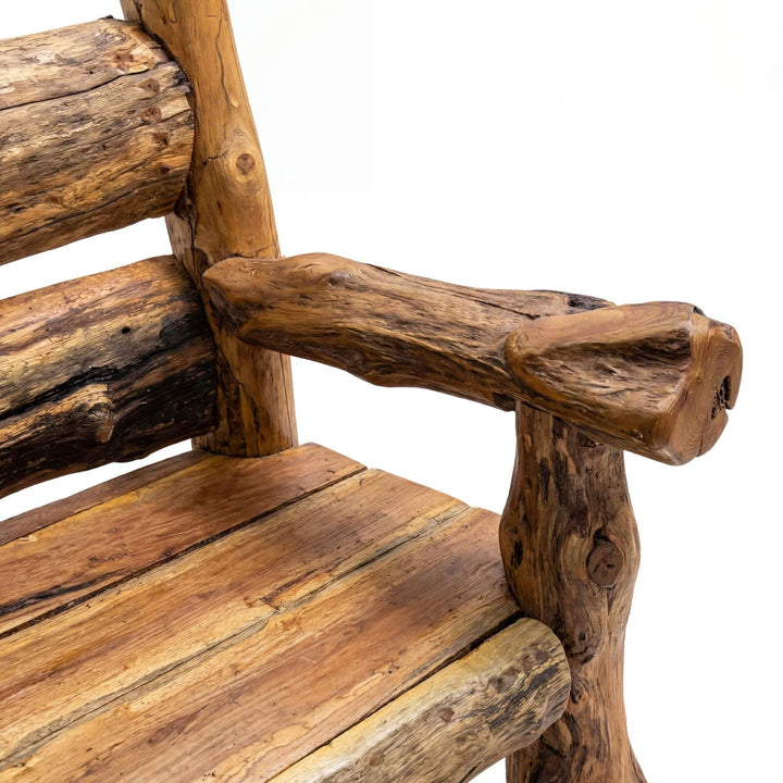 Close-up detail of the armrest and seat showing the aged teak texture and rustic joinery.