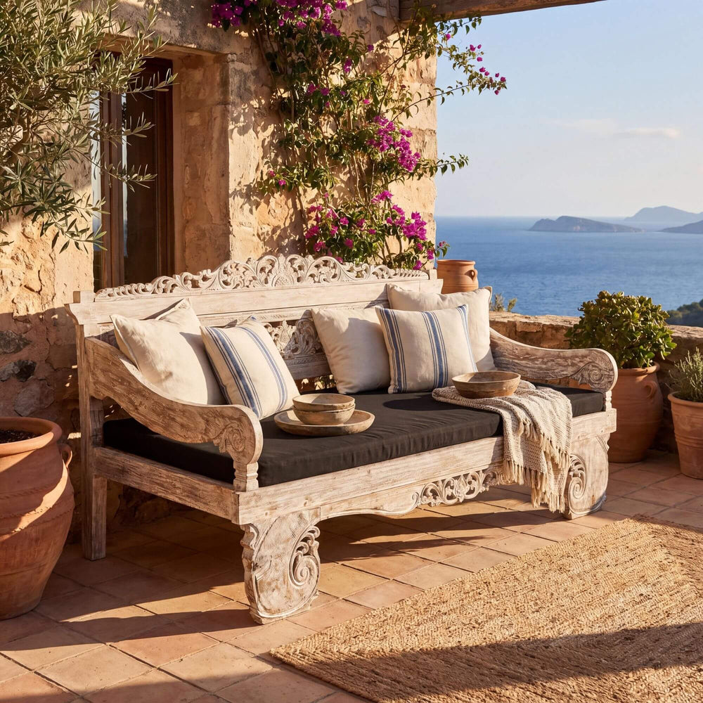Styled terrace setting featuring the Hela daybed in a warm Mediterranean outdoor space.