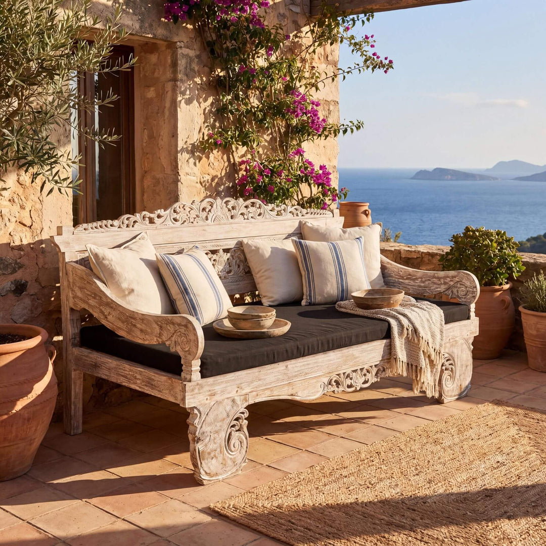 Styled terrace setting featuring the Hela daybed in a warm Mediterranean outdoor space.