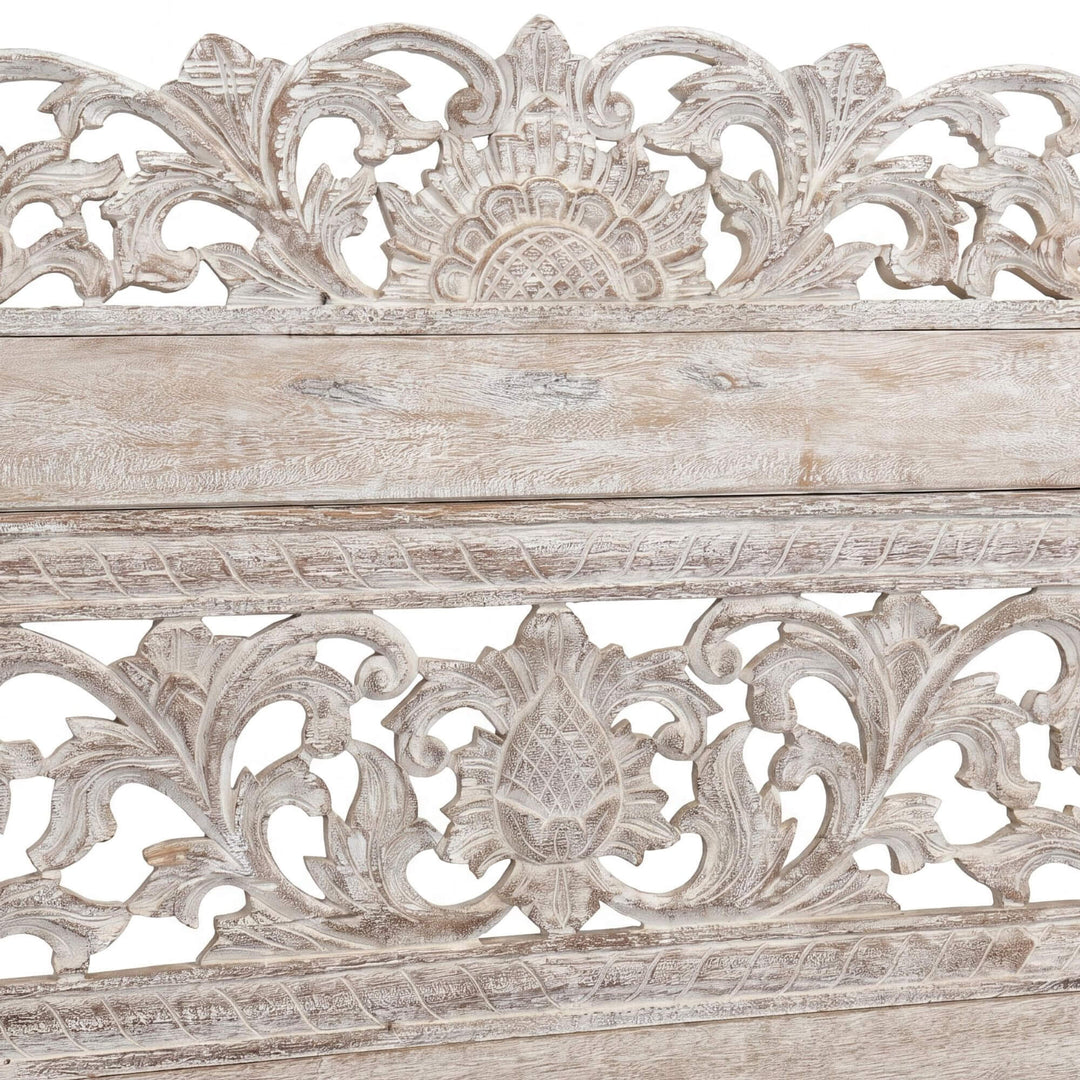 Close-up of the carved backrest showing the intricate Indonesian floral detailing.