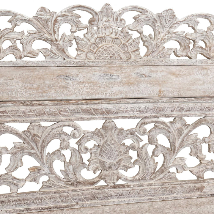 Close-up of the carved backrest showing the intricate Indonesian floral detailing.