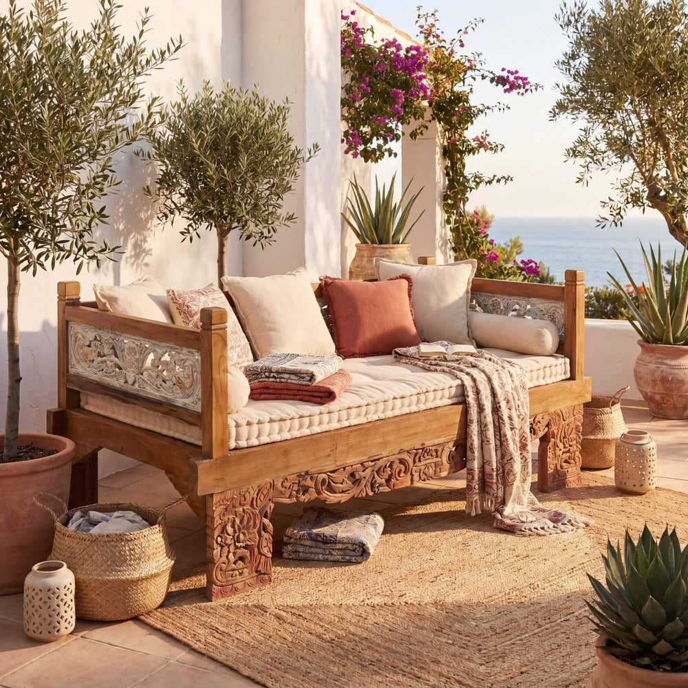 Styled terrace setting featuring the Hemera daybed with cushions in a warm Mediterranean-inspired outdoor space.