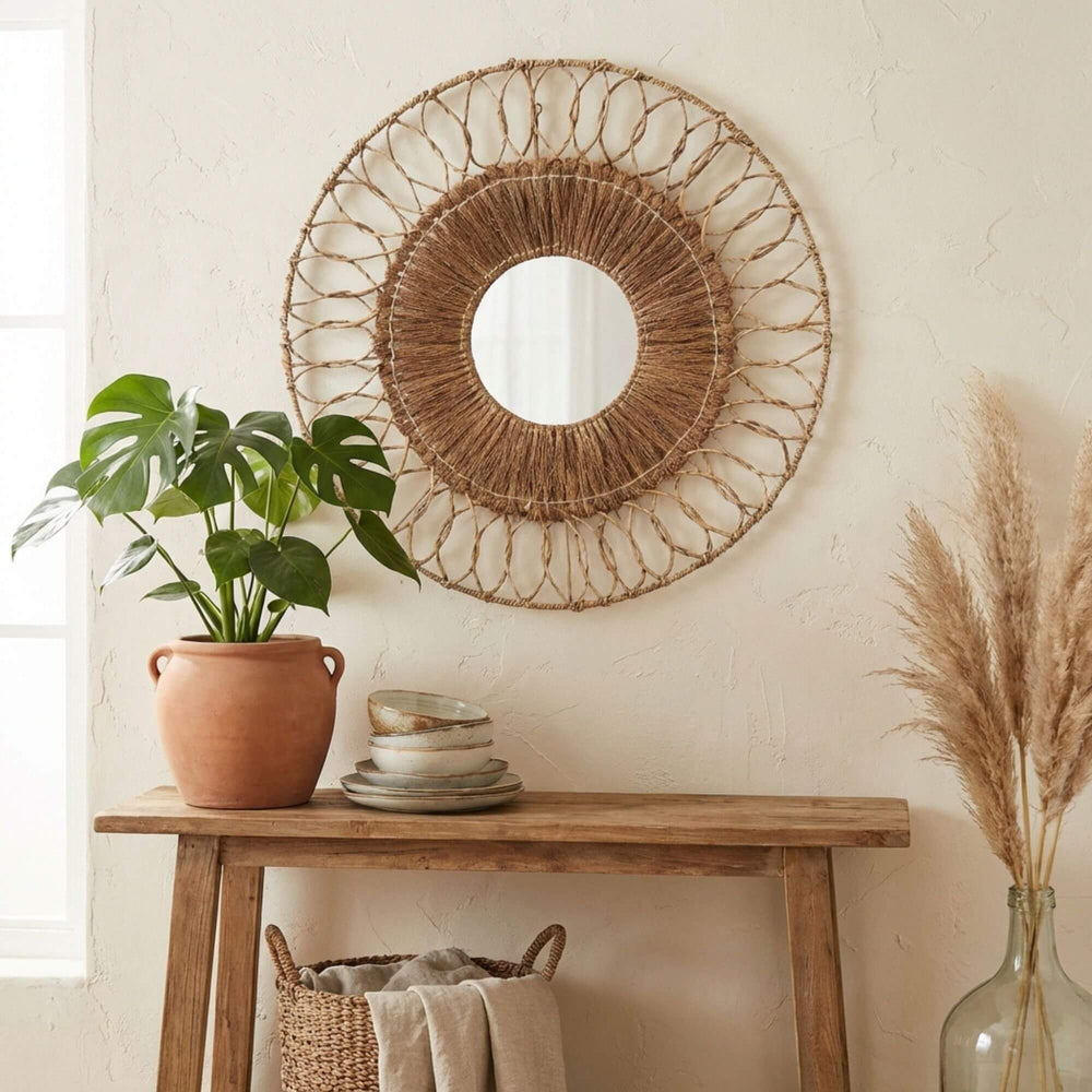 Woven wall Hemp mirror above a wooden console table with decor items.