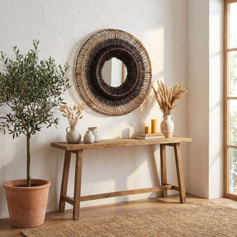 Wooden console table with decorative Hitam round mirror against a white wall
