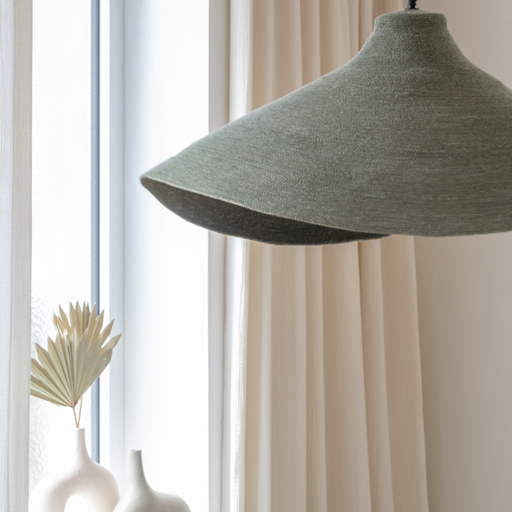 Green Hurgada ceiling lamp hanging above a dining table with natural light.