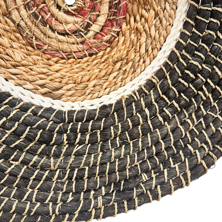 Close-up of Harum Wall Deco, handwoven from abaca, rattan, and cotton in a natural and black circular design.