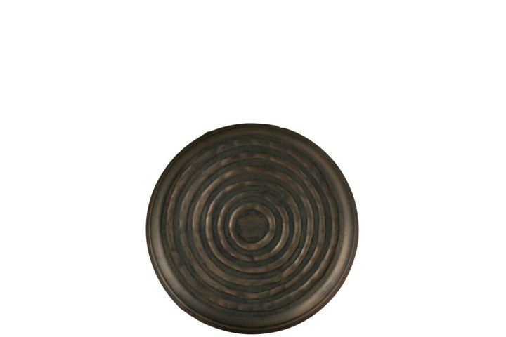 Front view of the round metal tray with concentric circular texture.