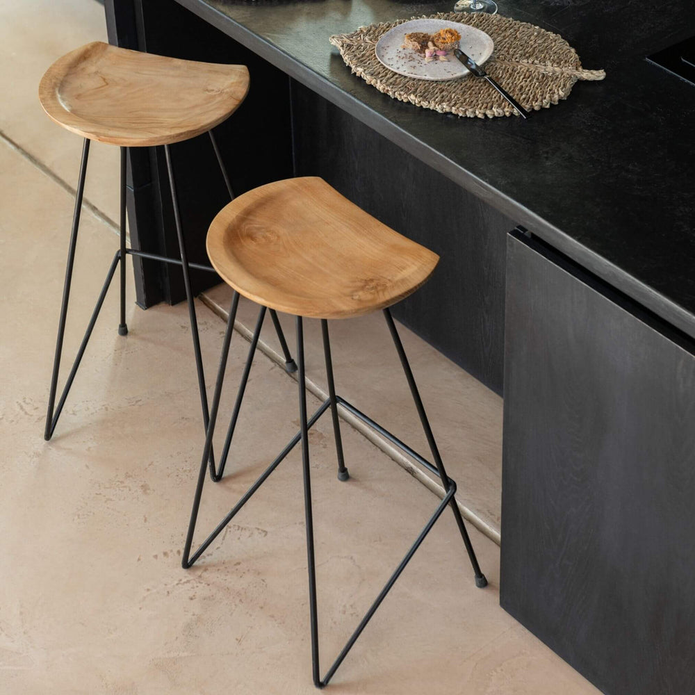 Lifestyle shot—pair of teak and iron bar chairs at kitchen island
