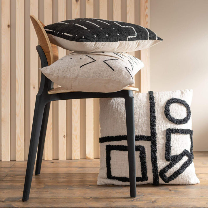Styled interior scene with the Jacob cushion placed on a black bar stool.
