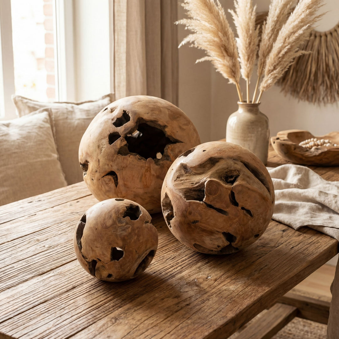 Styled interior setting with multiple teak root balls placed on a wooden table.
