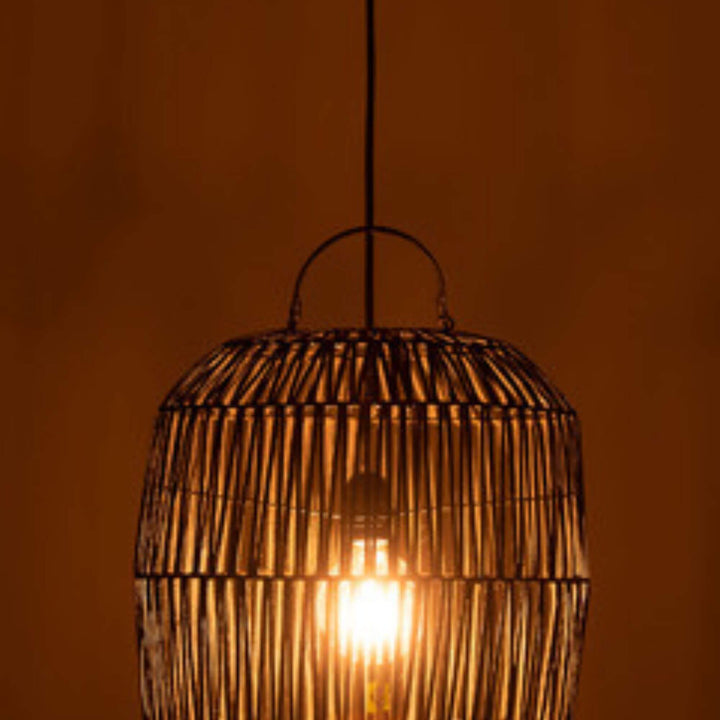 Java black rattan lamp lit at night creating warm glow