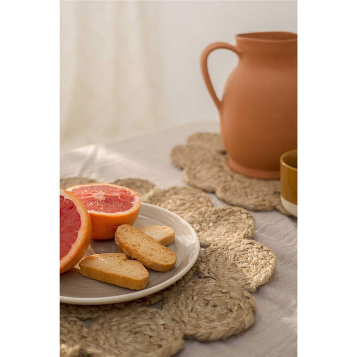 Styled table setting with Jute Andalucia Table Mat, ceramic jug, and fruit plate.

