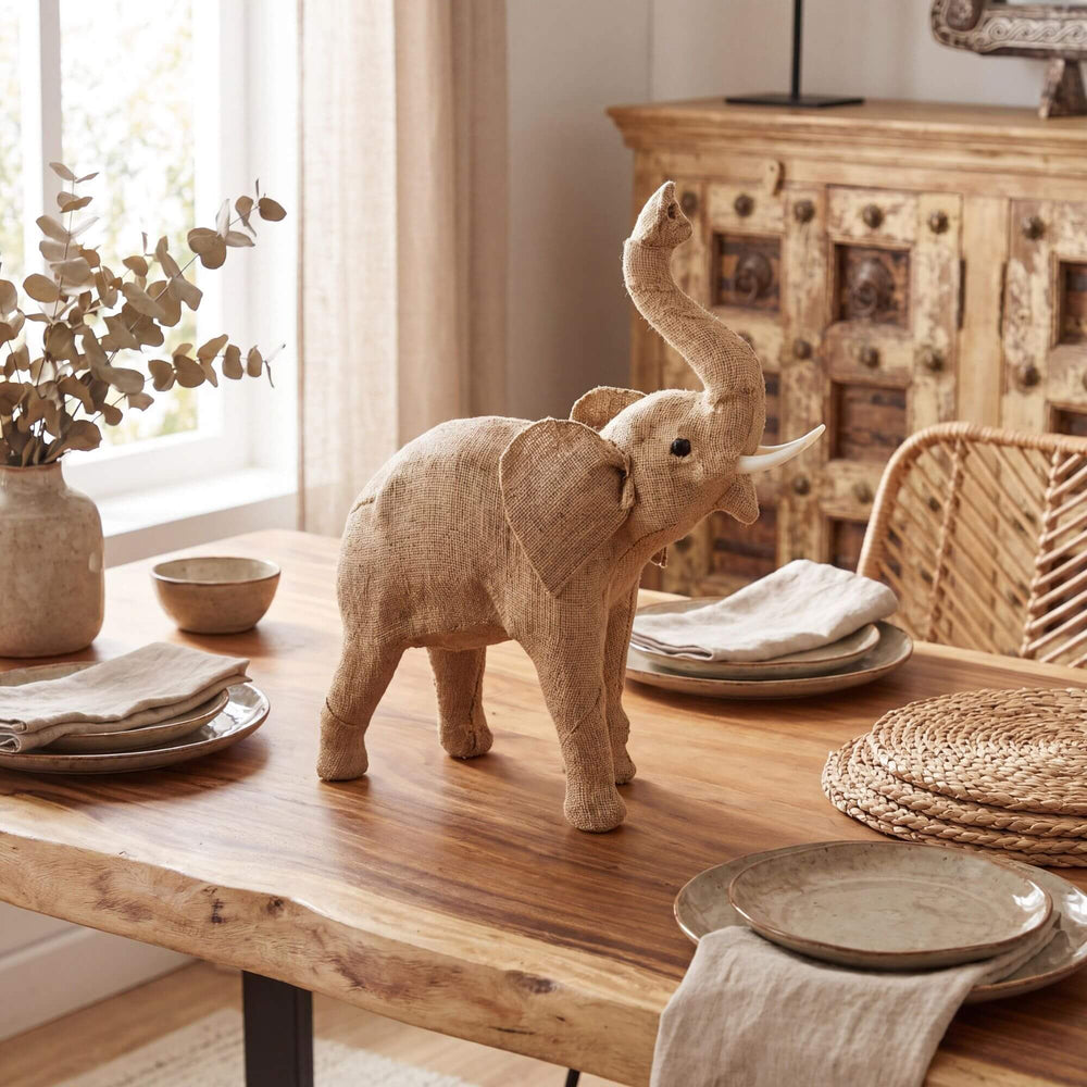 Styled tabletop setting featuring the jute elephant as a decorative accent in a warm natural interior.