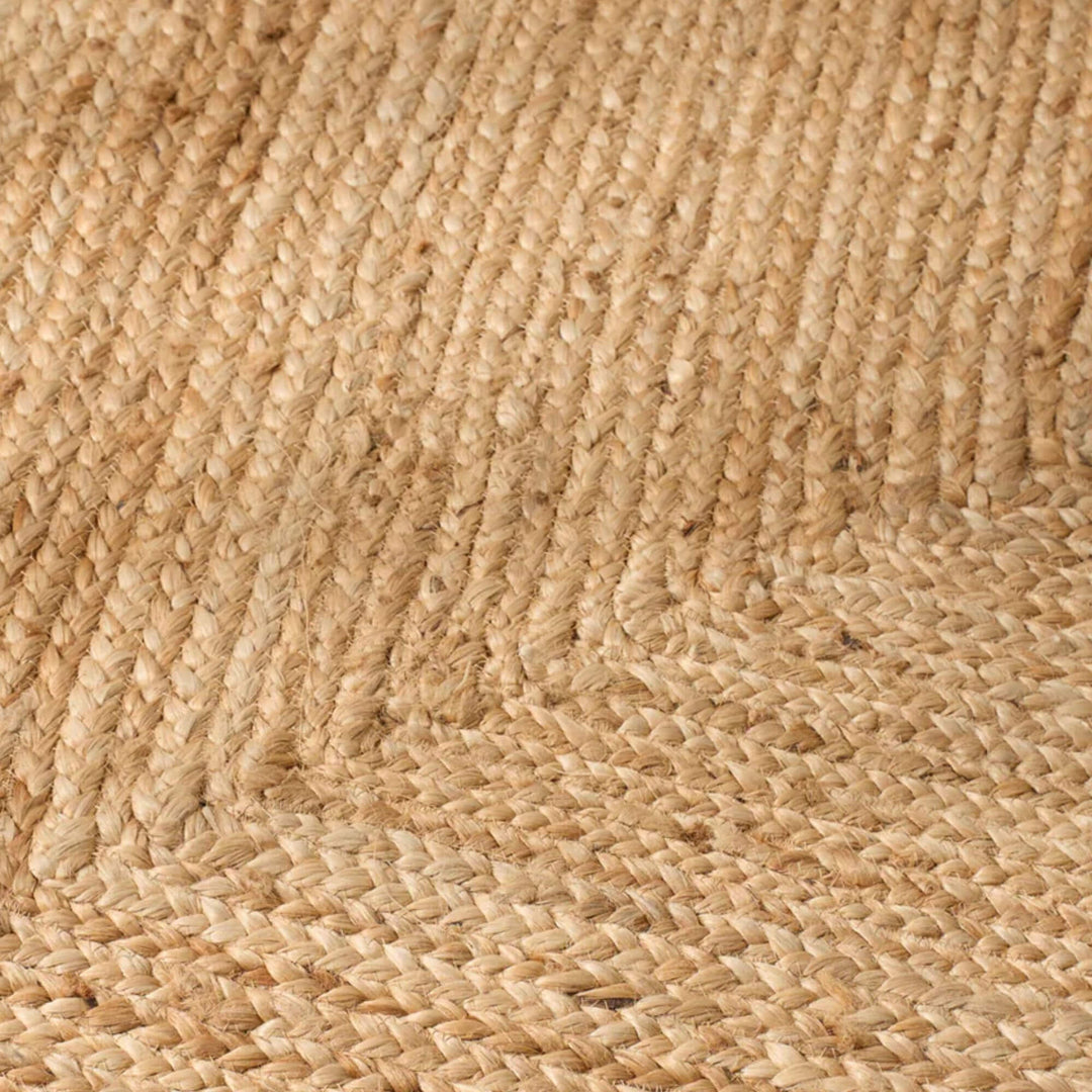 Detail of the rectangular jute rug highlighting the directional border weave and natural fiber texture