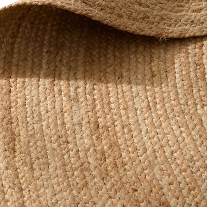 Detail view of the round jute rug highlighting the organic weave and warm earthy tones