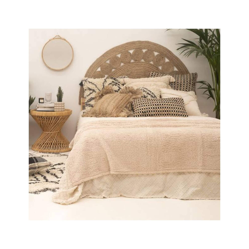 Bedroom styled with jute wall headboard, neutral bedding, and organic textures.