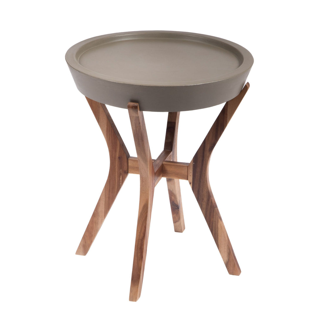 Front angled view of the Kaia side table showing its round waxed concrete tray top and sculptural curved acacia wood legs.