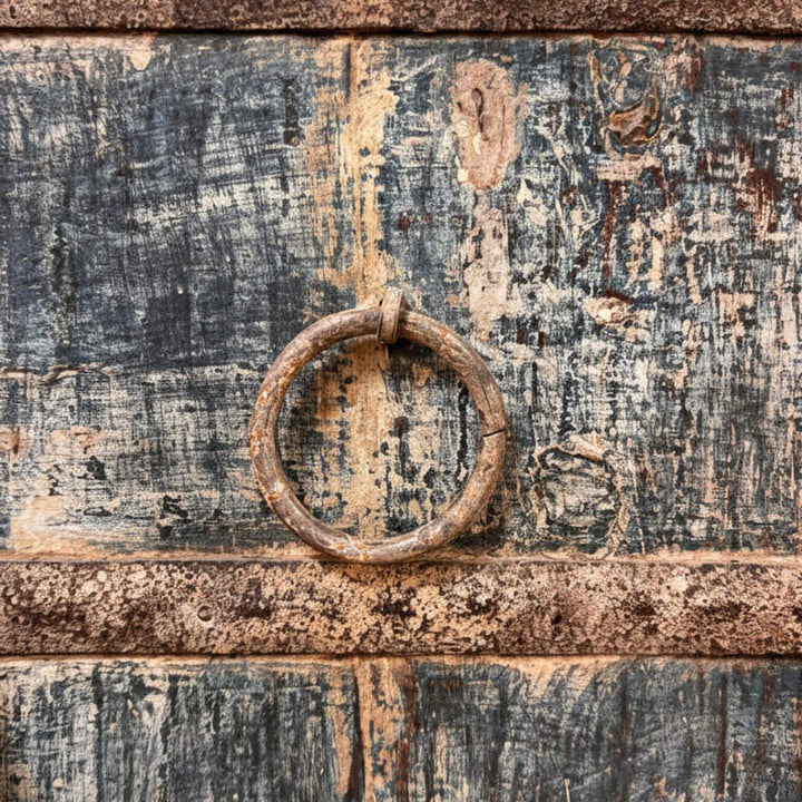 Detail of the antique ring handle and distressed wood texture.
