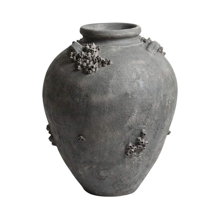 Angled view of the terracotta vase highlighting its organic volcanic-like details.
