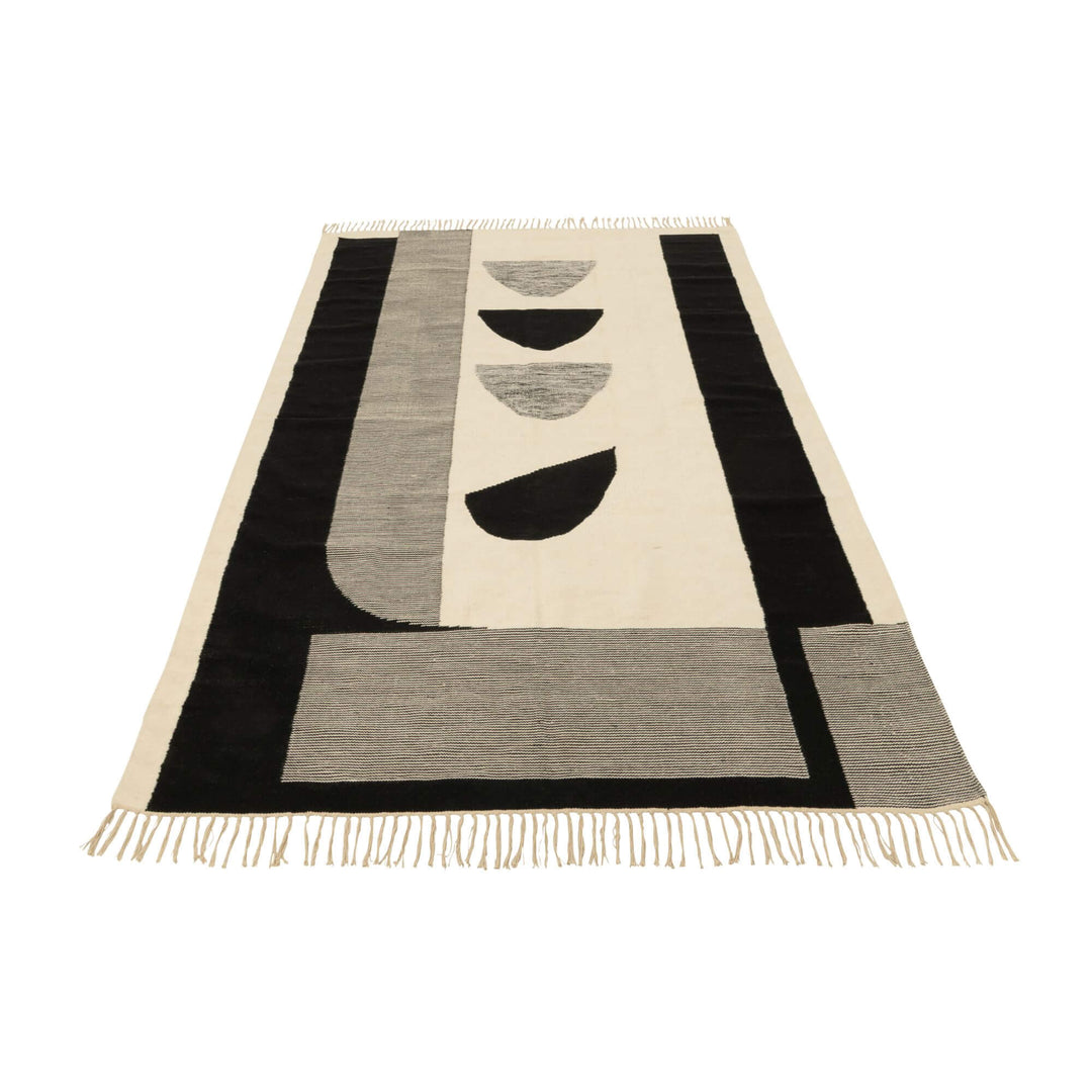 Front view of the Kenai rug featuring a black, grey and natural geometric design.