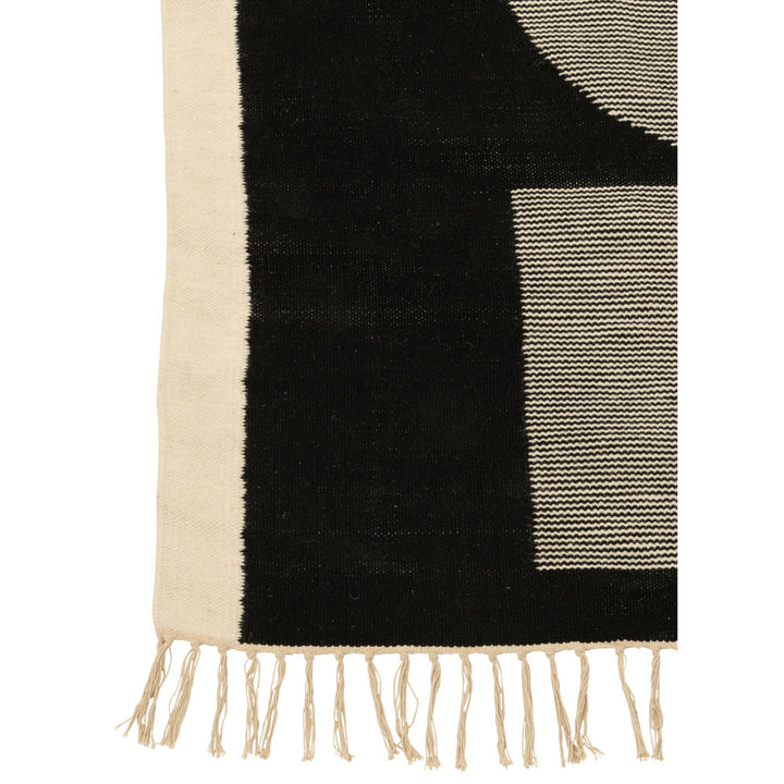 Close-up of the Kenai rug showing the geometric shapes and textured polyester surface.