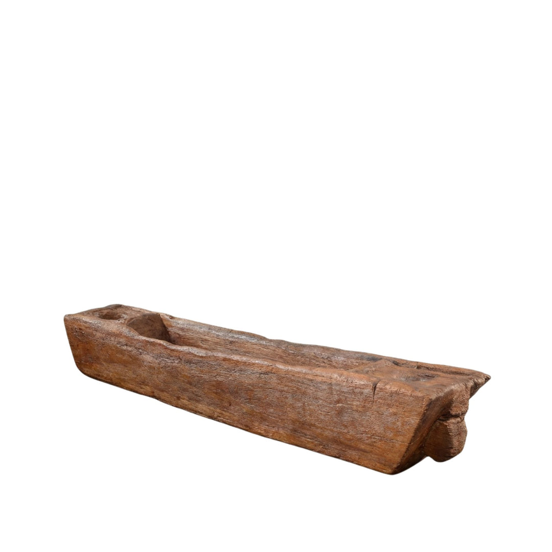 Front view of the Komodo Lumpang teak wood planter showcasing its elongated carved form.