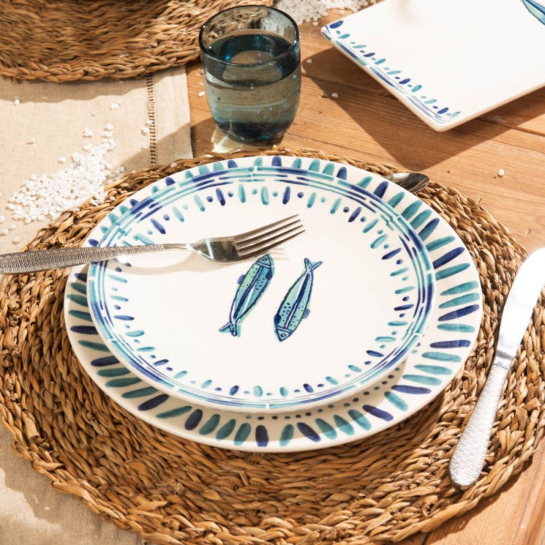 Kyanos ceramic plate styled on a natural placemat with blue fish decoration
