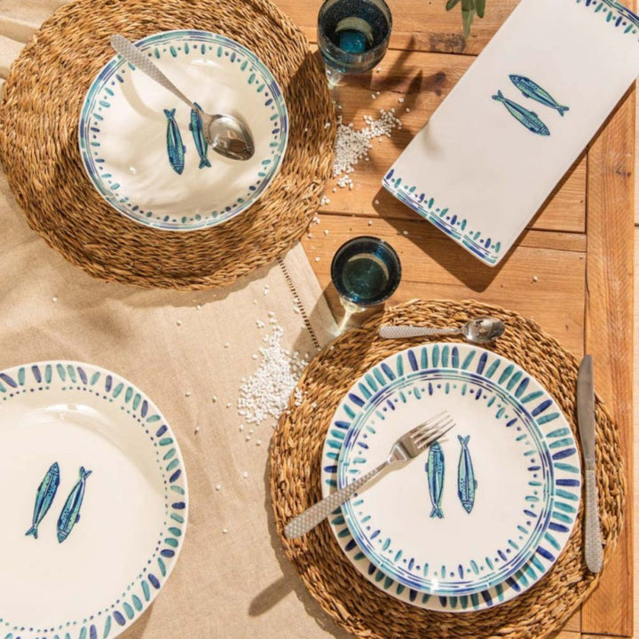 Overhead view of Kyanos tableware arranged on a wooden table with coordinated ceramic pieces