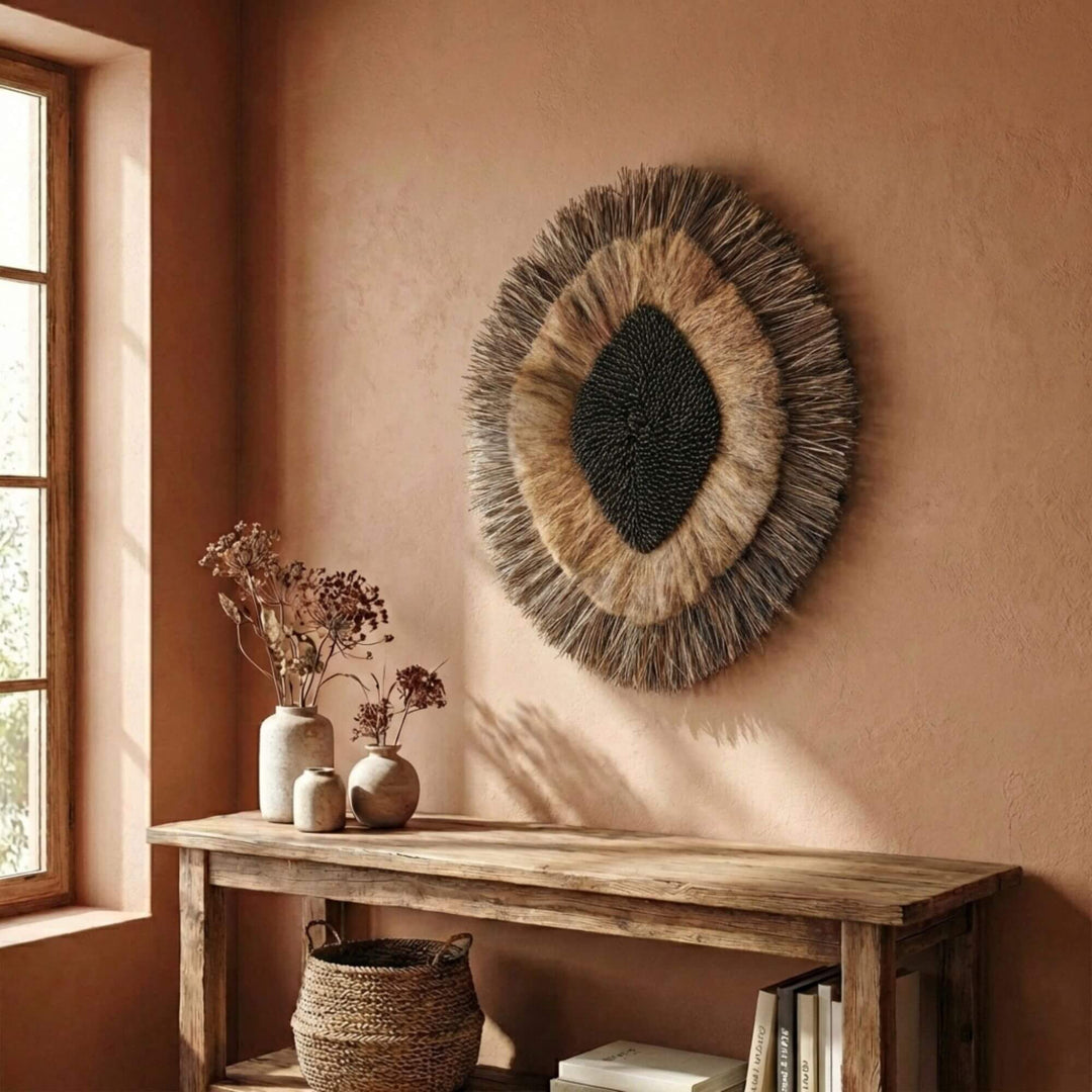 Woven Laras wall deco on a warm-toned wall with a wooden console table and decor items.
