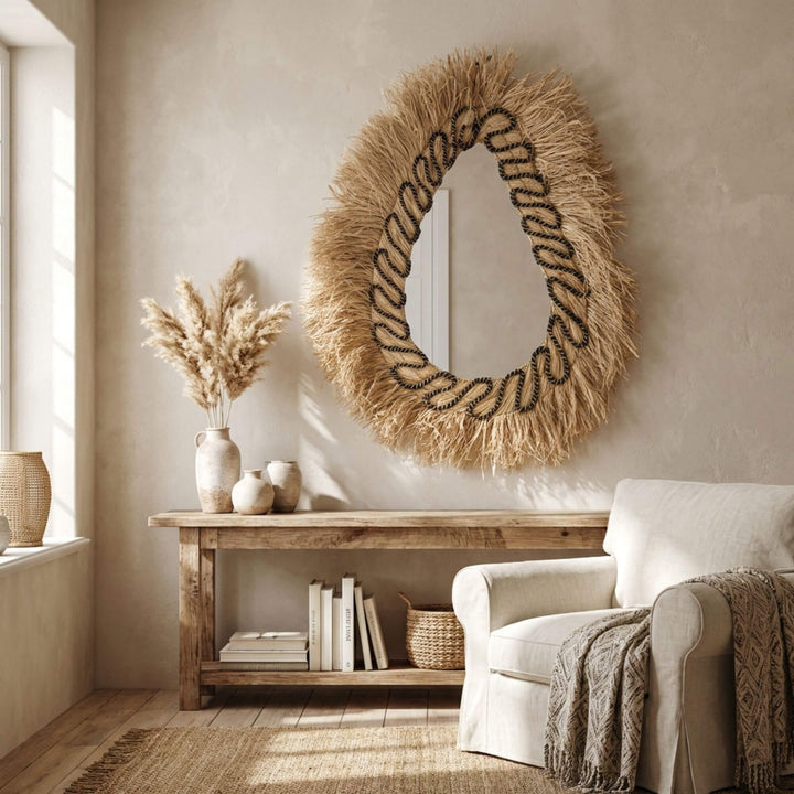 Living room with a decorative Lautan mirror, books, and a vase on a wooden console table.