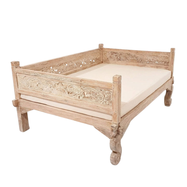 Angled view of the Lavinia daybed emphasizing the carved side panels and sturdy teak construction.