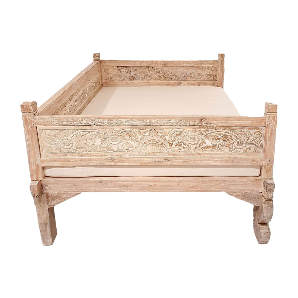 Side angle of Lavinia teak wood daybed showing ornate hand-carved details