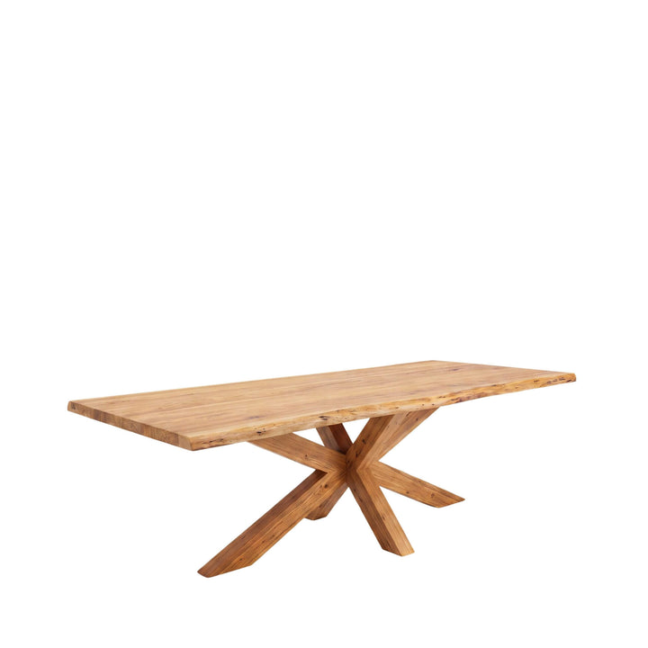 Front angled view of the Lea dining table in acacia wood with a natural-edge top and sculptural crossed-leg base