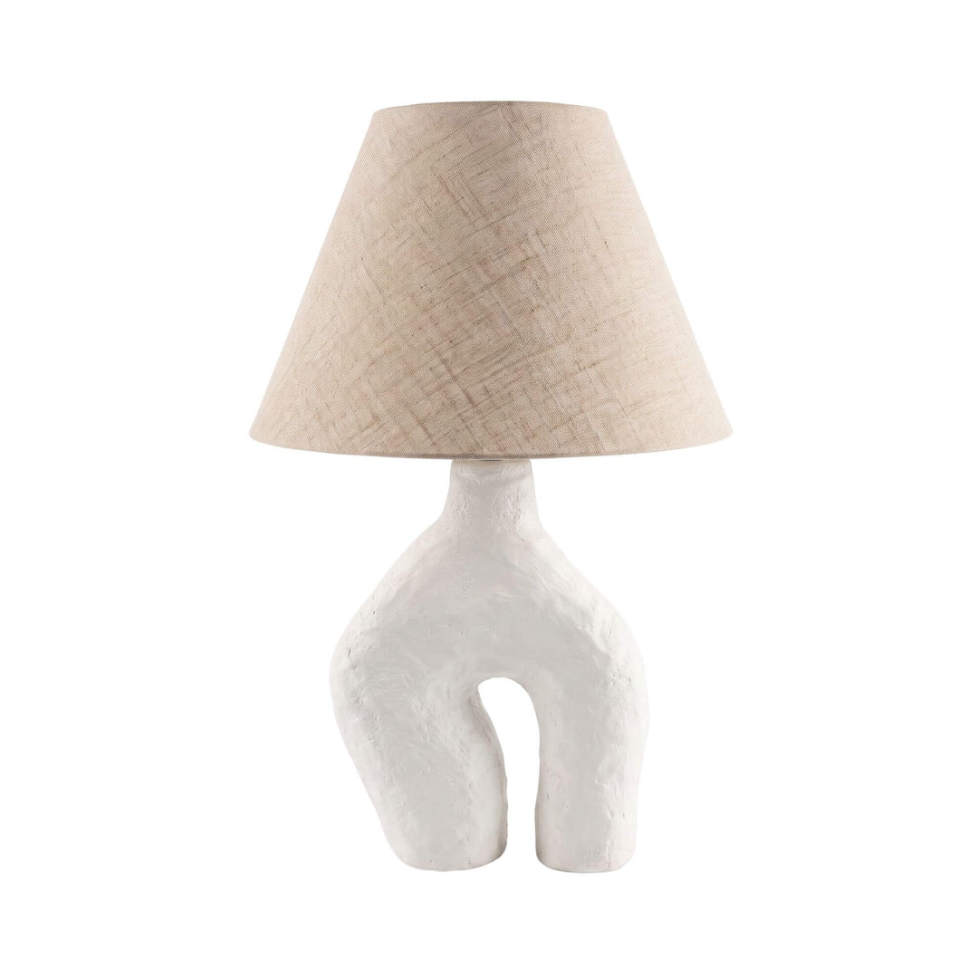 Front view of the Legy table lamp with a sculptural off-white papier-mâché base and natural linen shade