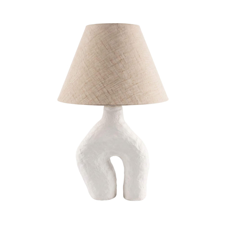 Front view of the Legy table lamp with a sculptural off-white papier-mâché base and natural linen shade