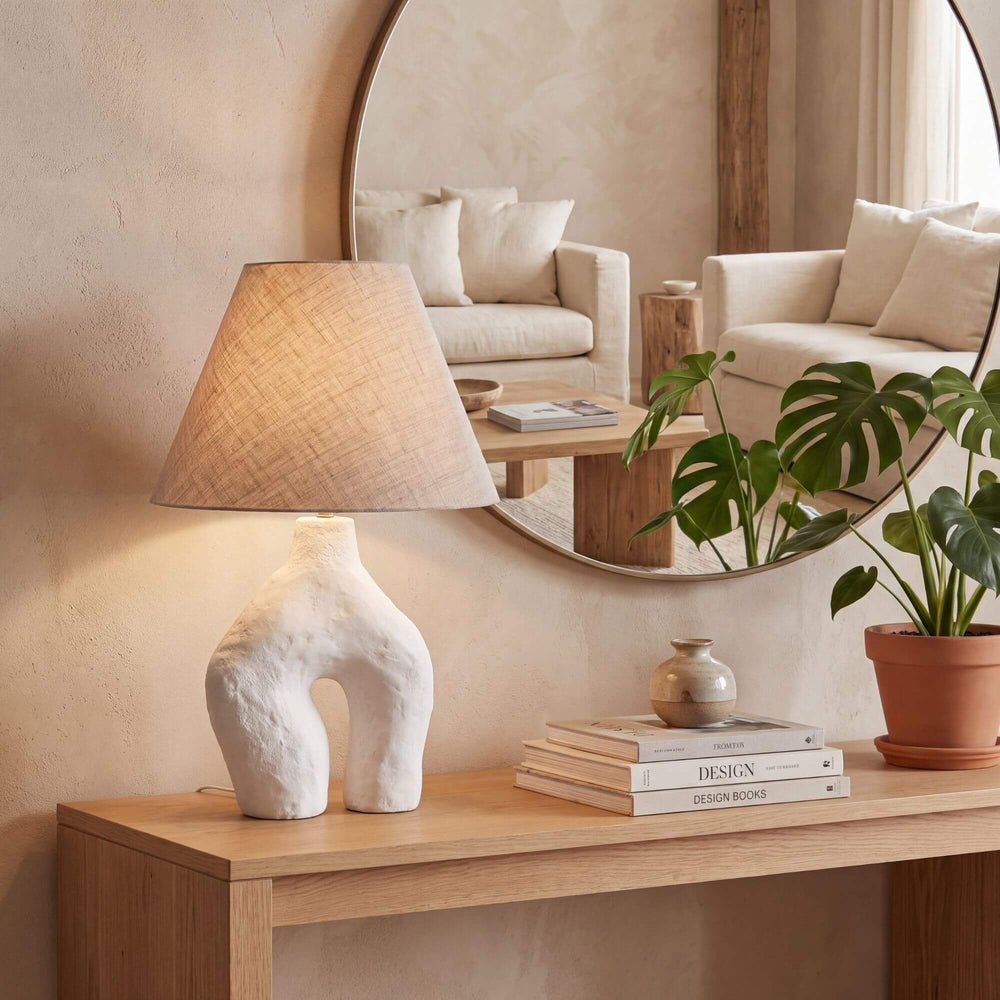Legy table lamp styled on a wooden console beneath a round mirror in a warm neutral interior