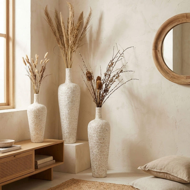 Linart ceramic vases with dried plants in a room with a wooden cabinet and mirror.