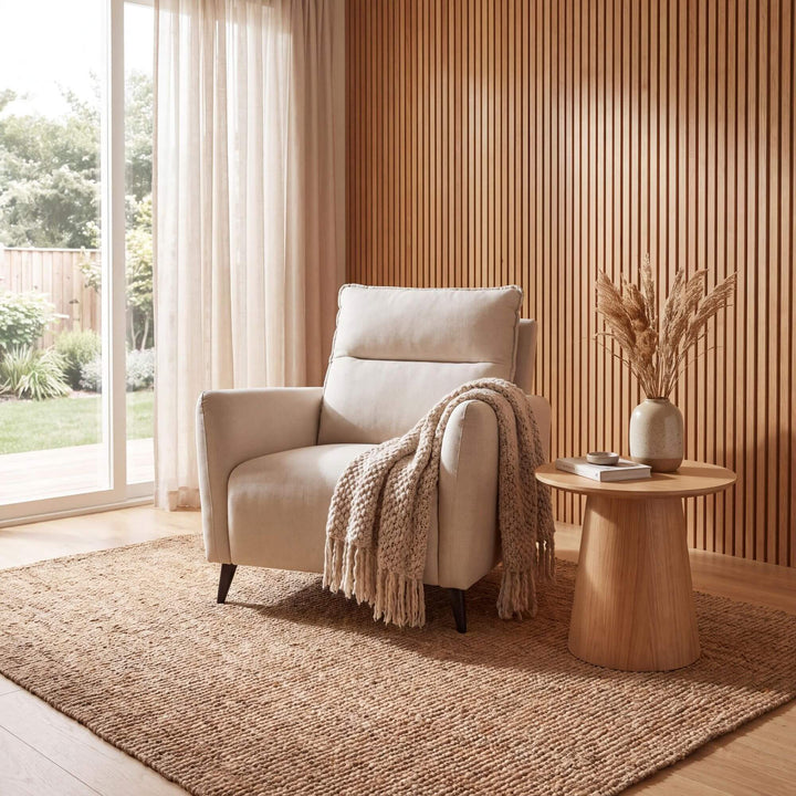 Styled reading corner featuring the Livorno armchair in a warm natural interior beside a wooden side table.