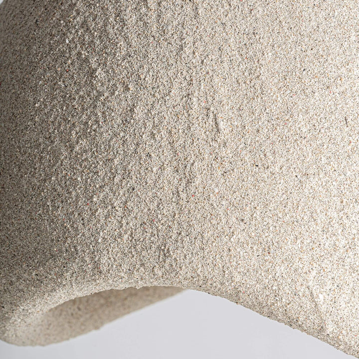 Close-up of the Lua ceiling lamp highlighting the textured resin surface and asymmetrical lower opening