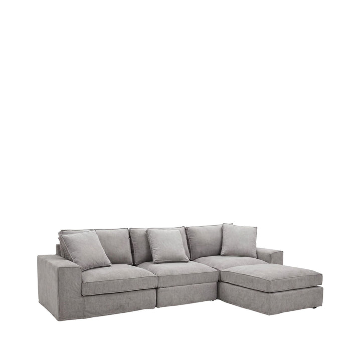 Front view of the Lucca sofa with matching pouf showing its soft neutral upholstery and relaxed proportions.