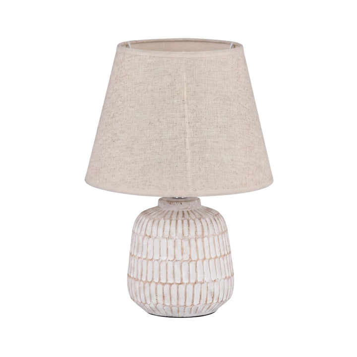 Front view of the white textured ceramic Luma lamp with a natural fabric shade.