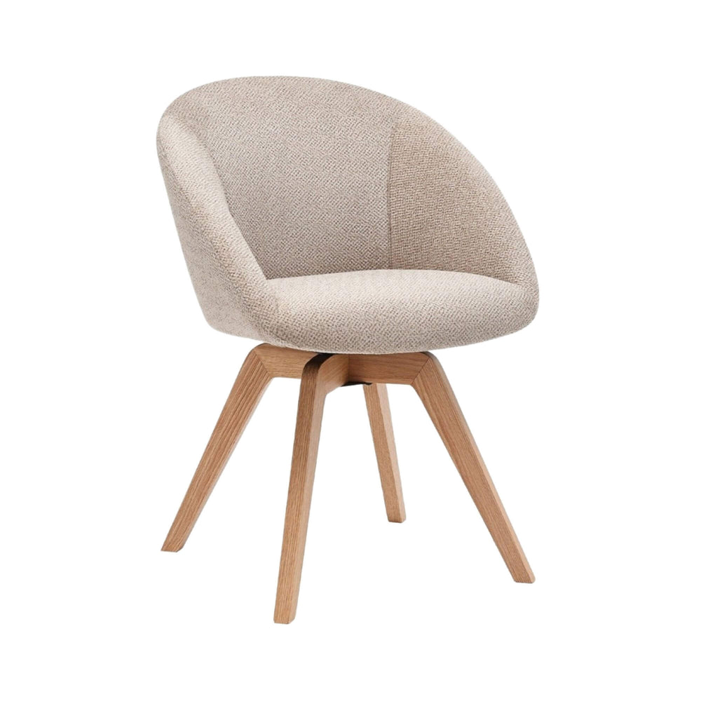 Angled view of the Lume dining chair showing its curved upholstered seat and ash wood legs.