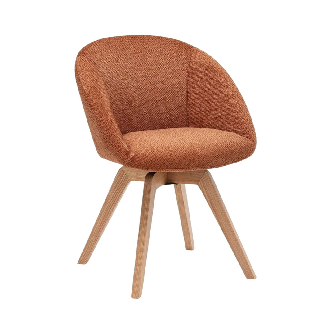 Angled view of the Lume dining chair showing its curved upholstered seat and ash wood legs.