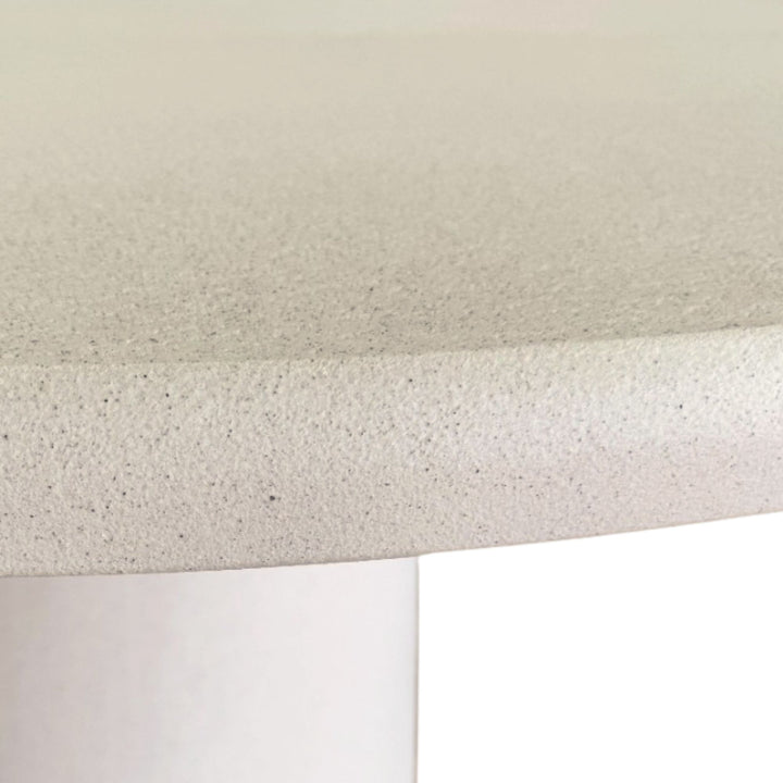 Side detail of the tabletop highlighting the soft rounded edge and refined microcement finish.
