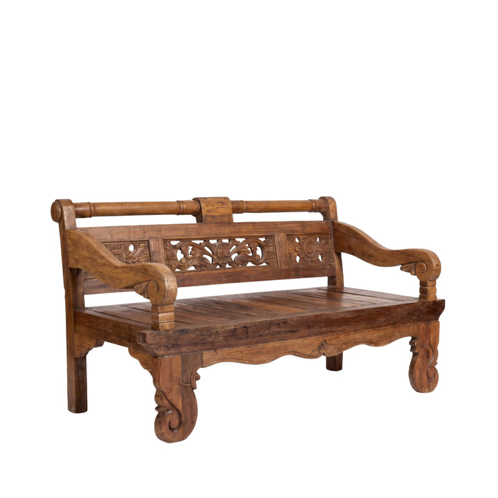 Front angled view of the Luna Indonesian carved teak wood daybed showing its carved backrest, sculptural arms, and solid wood seat.