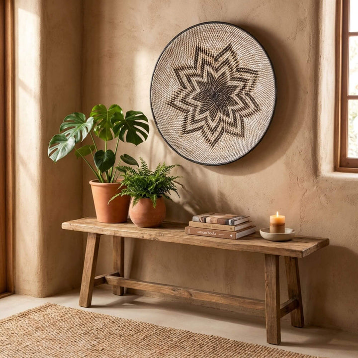 Nest living room with wooden bench, plants, and decorative Lyra wall art.