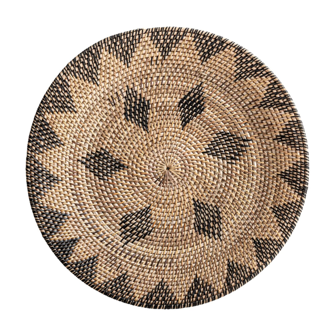 Handwoven rattan decorative plate in natural and black geometric pattern from the Lyra Collection.