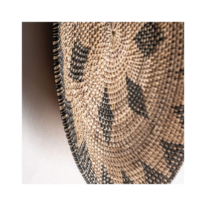 Close-up of Lyra Collection rattan wall plate showing detailed weaving texture.


